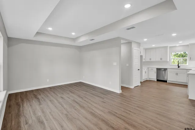 a view of empty room with wooden floor and window
