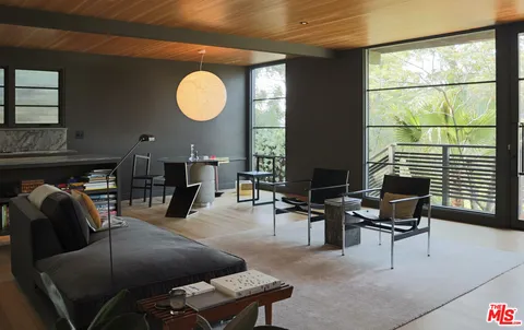 a living room with furniture a rug and a large window