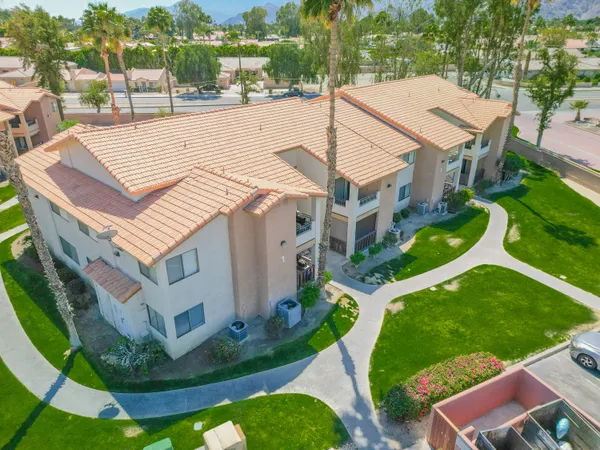 a view of a white house with a yard table and chairs
