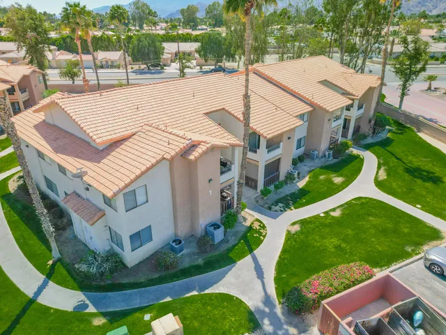 a view of a white house with a yard table and chairs