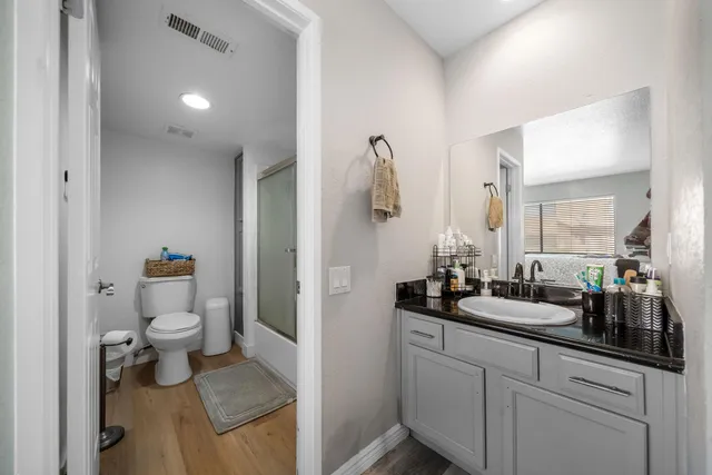 a bathroom with a sink and mirror with toilet