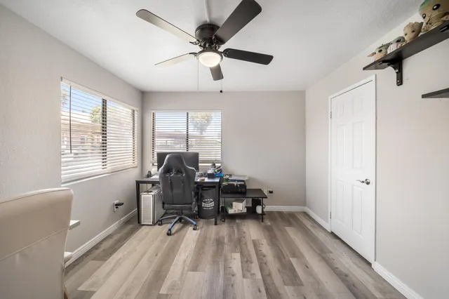 a view of a workspace with furniture and a window