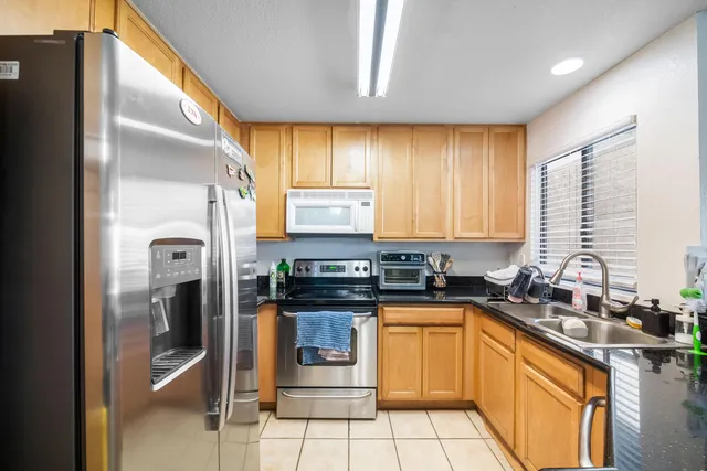 a kitchen with granite countertop a sink stainless steel appliances and cabinets