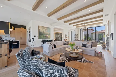 a large kitchen with kitchen island a stove a sink a dining table and chairs with wooden floor