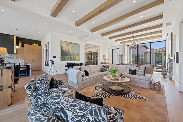 a large kitchen with kitchen island a stove a sink a dining table and chairs with wooden floor