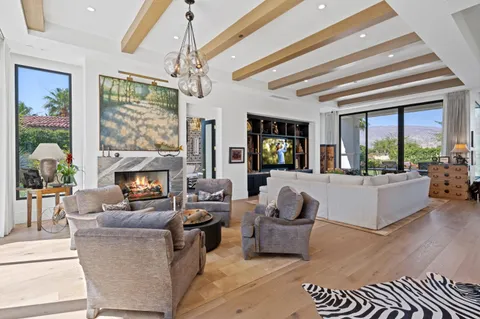 a living room with fireplace furniture and a chandelier