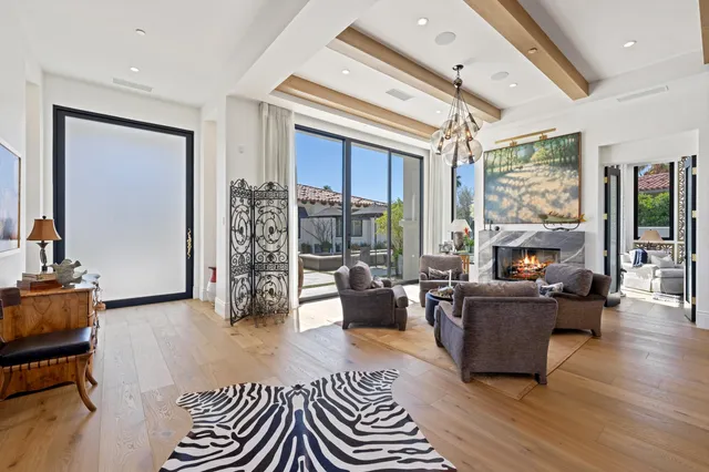 a living room with furniture kitchen view and a large window