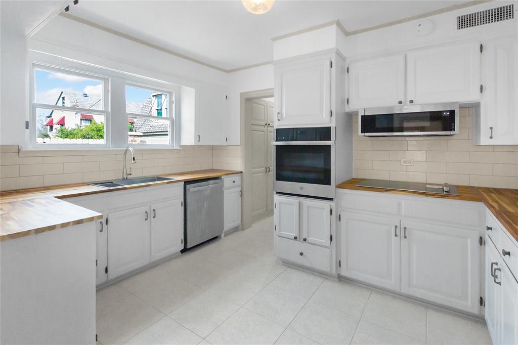 401 West 4th Street Tyler, TX 75701 - Photo 11 of 34 a kitchen with white cabinets stainless steel appliances and sink