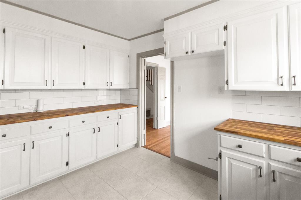 401 West 4th Street Tyler, TX 75701 - Photo 12 of 34 a kitchen with granite countertop white cabinets and white appliances