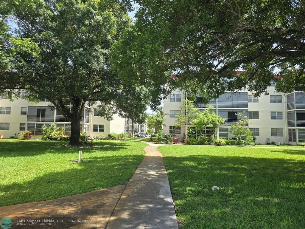 3000 Northwest 48th Terrace, Unit 430 Lauderdale Lakes, FL 33313 - Photo 12 of 15 a front view of a building with a garden