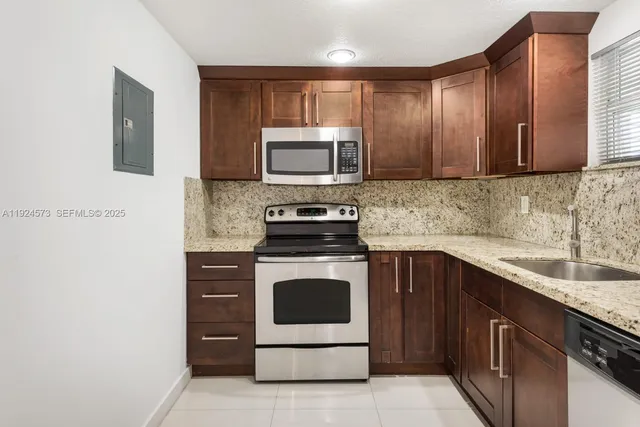 a kitchen with sink a microwave and cabinets