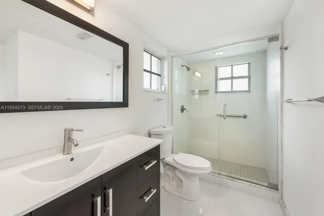 a bathroom with a sink a toilet and shower