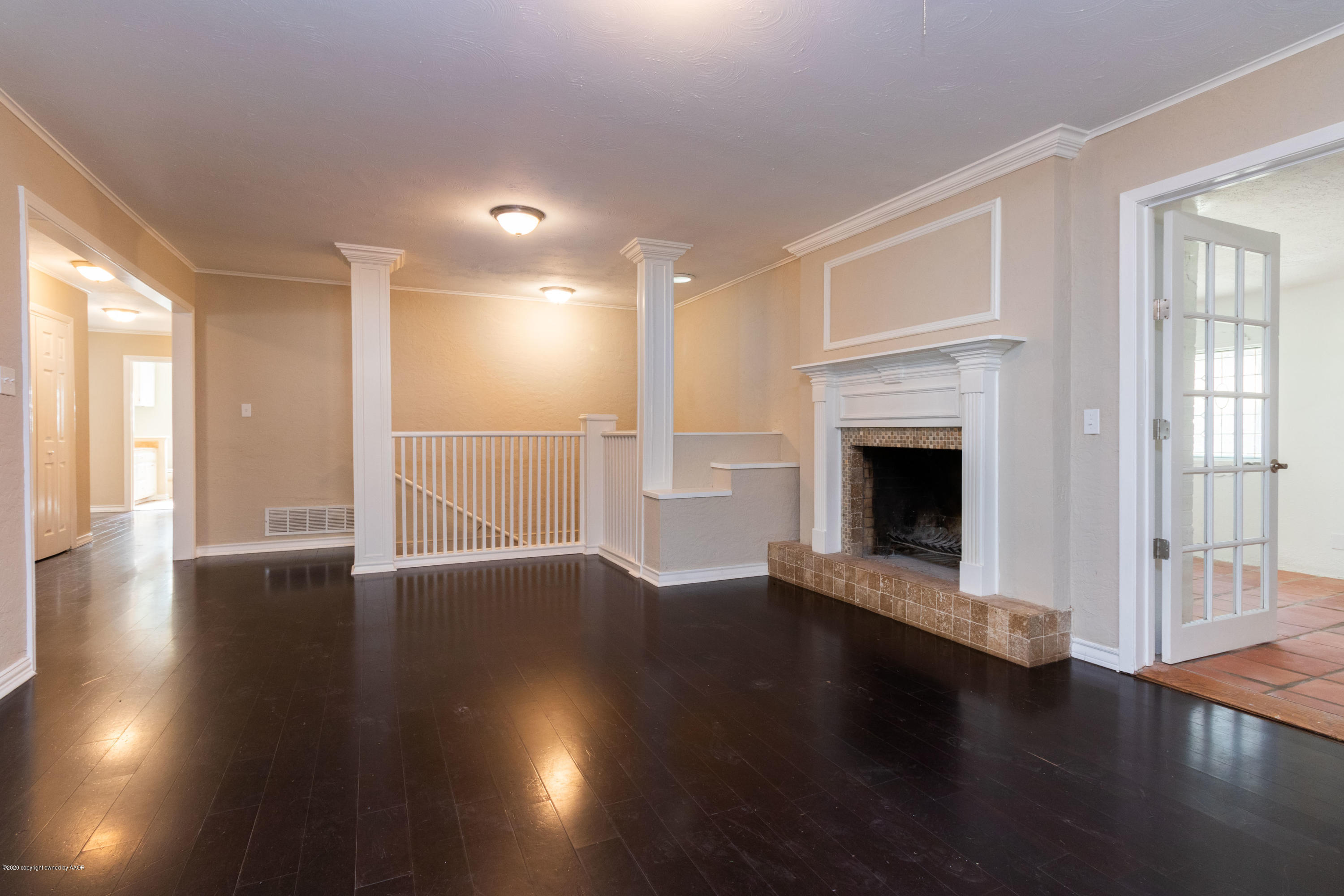 6605 Dreyfuss Road Amarillo, TX 79106 - Photo 7 of 39 an empty room with wooden floor fireplace and windows