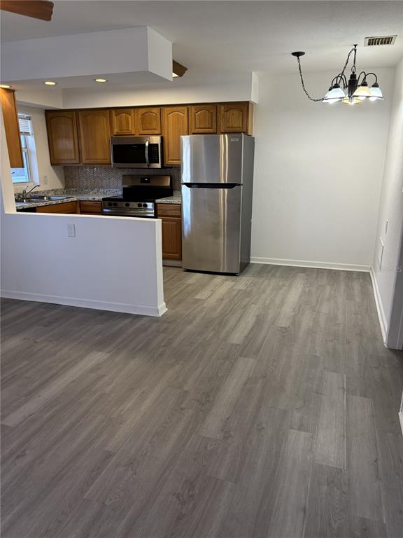 9030 Blind Pass Road, Unit C7 St. Petersburg, FL 33706 - Photo 6 of 16 a kitchen with granite countertop a refrigerator and a stove top oven