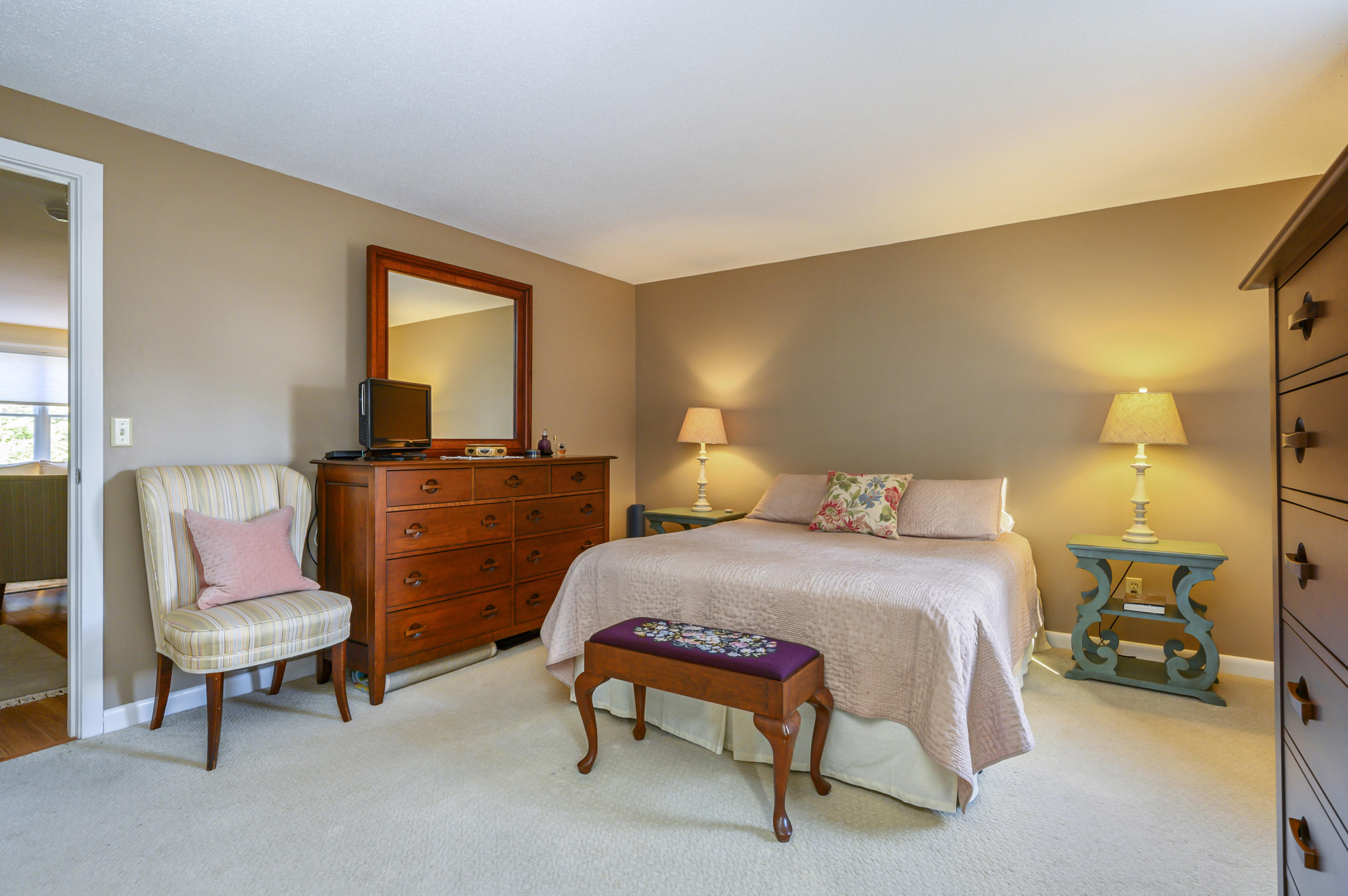 Undisclosed Address Mashpee, MA 02649 - Photo 14 of 21 a bedroom with a bed a chair and dresser next to a window