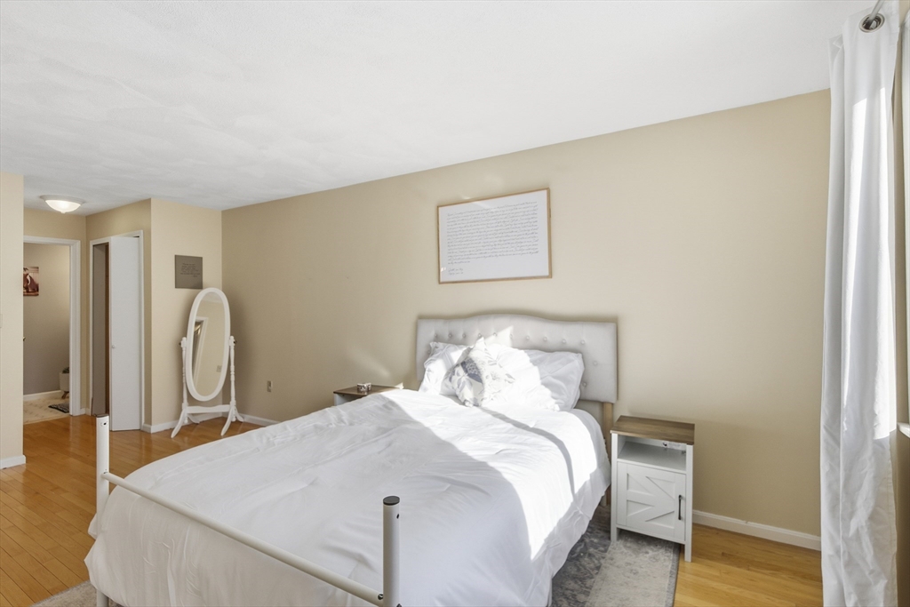 4 Erick Road, Unit 90 Mansfield, MA 02048 - Photo 16 of 30 a bedroom with a bed and wooden floor