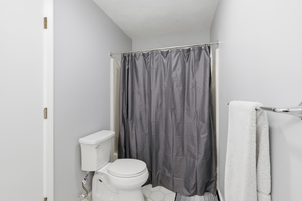 4 Erick Road, Unit 90 Mansfield, MA 02048 - Photo 18 of 30 a white toilet sitting next to a shower curtain