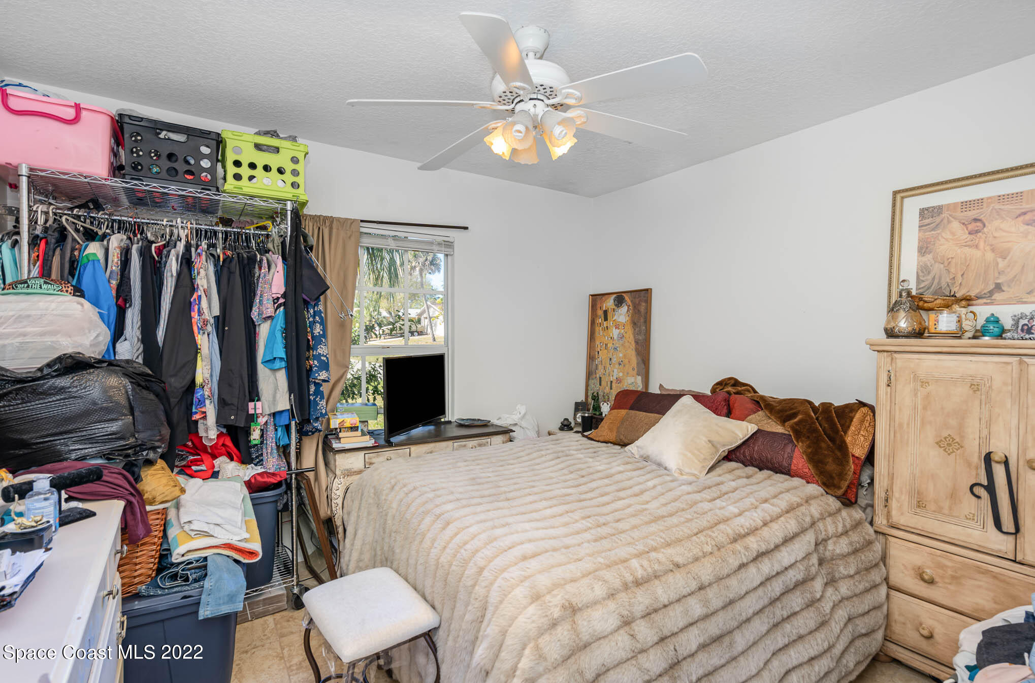1247 Van Tassel Trail Palm Bay, FL 32905 - Photo 20 of 31 a bedroom with a bed a walk in closet and a window