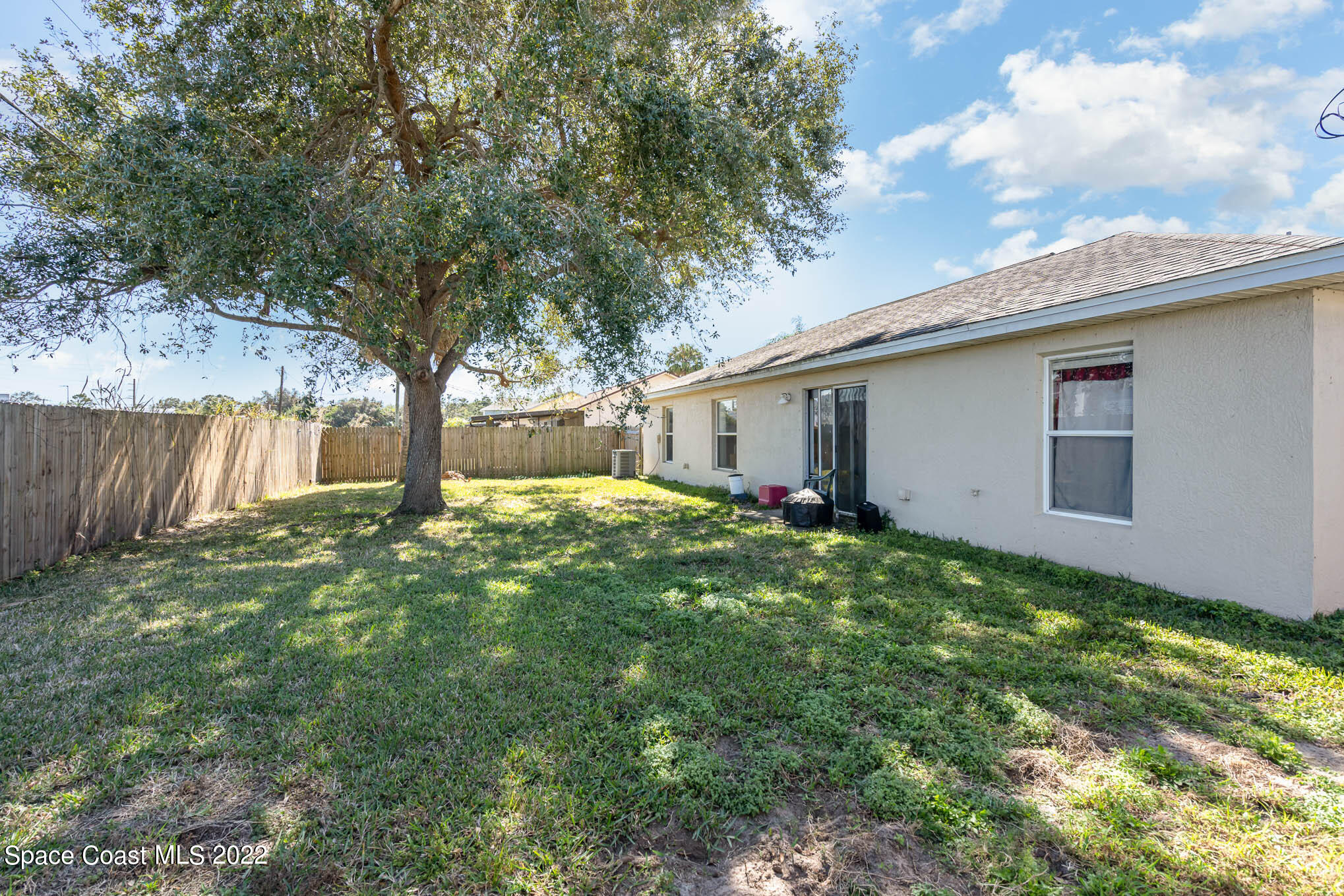 1247 Van Tassel Trail Palm Bay, FL 32905 - Photo 28 of 31 a backyard of a house with plants and large tree
