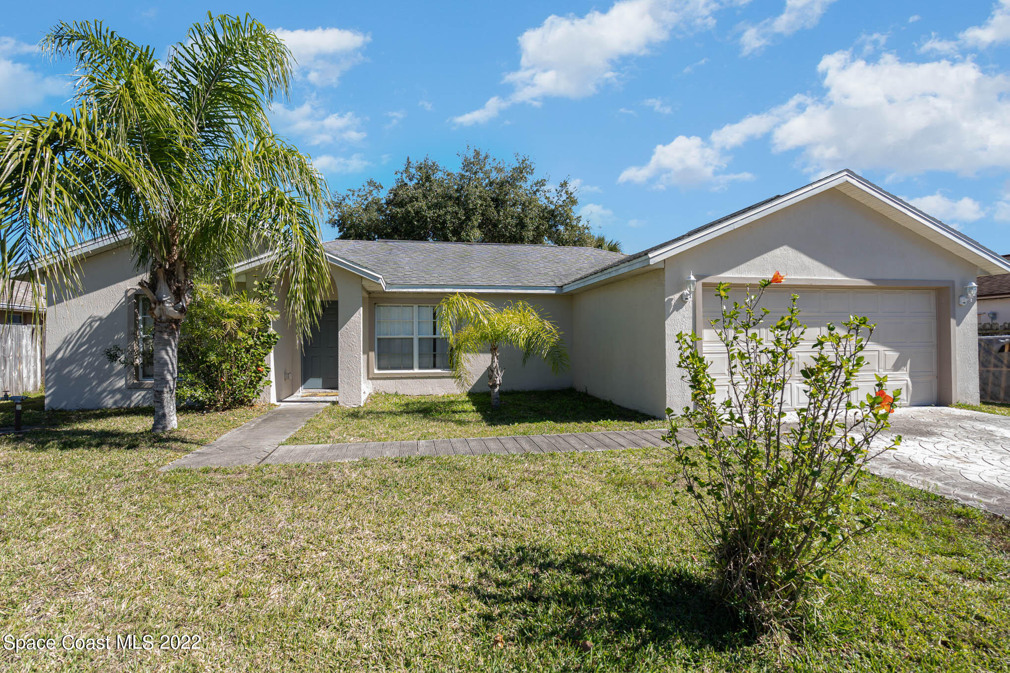 1247 Van Tassel Trail Palm Bay, FL 32905 - Photo 31 of 31 a view of a house with a large tree and a yard