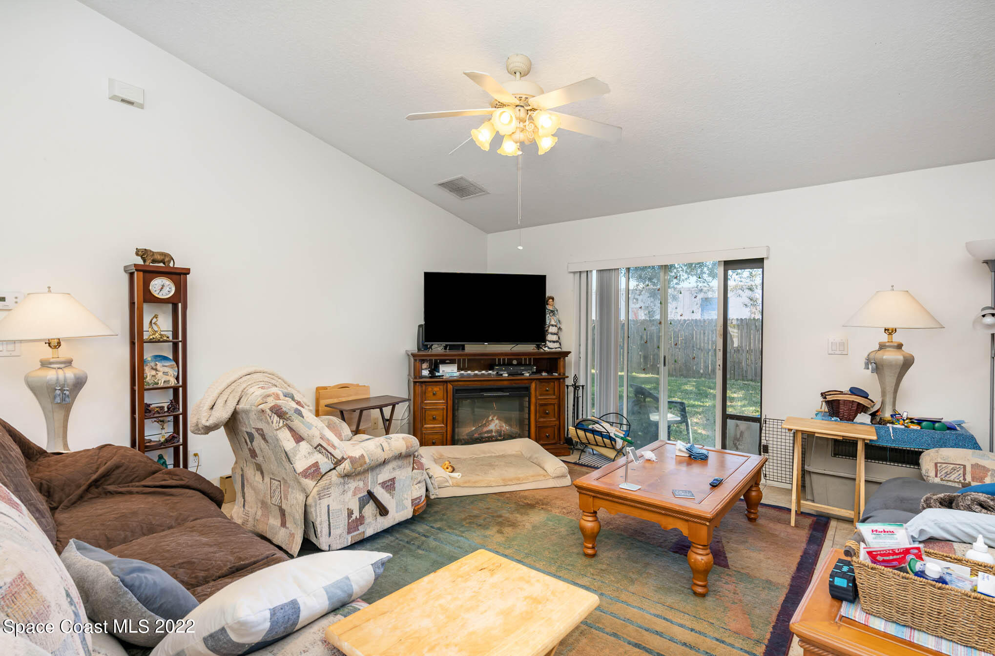 1247 Van Tassel Trail Palm Bay, FL 32905 - Photo 6 of 31 a living room with furniture a flat screen tv and a large window