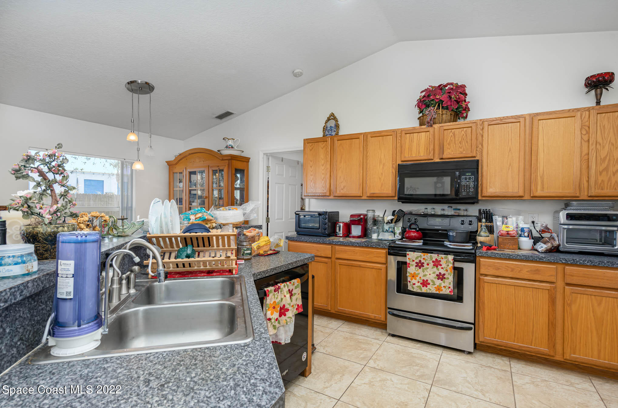 1247 Van Tassel Trail Palm Bay, FL 32905 - Photo 10 of 31 a kitchen with stainless steel appliances granite countertop a stove top oven a sink dishwasher and a microwave with wooden floor