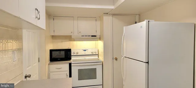a white refrigerator freezer and a stove sitting inside of a kitchen