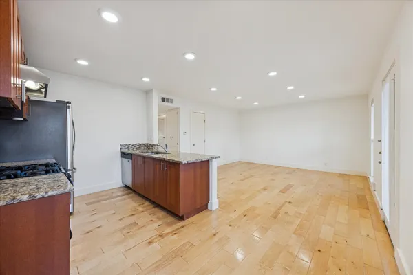 a kitchen with stainless steel appliances granite countertop a stove a sink and a refrigerator