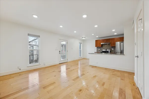 an empty room with wooden floor and windows