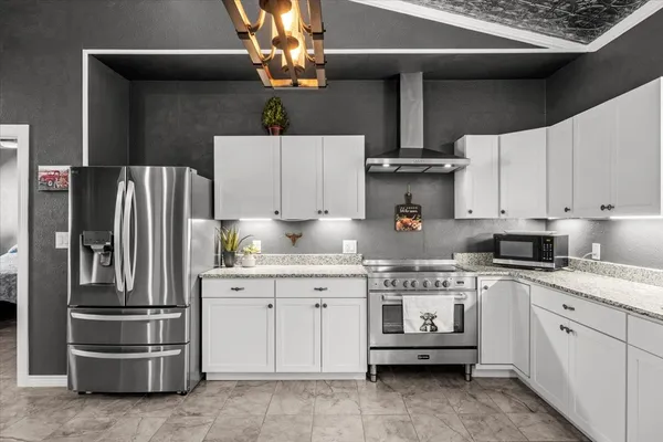 a kitchen with stainless steel appliances a stove a refrigerator and cabinets