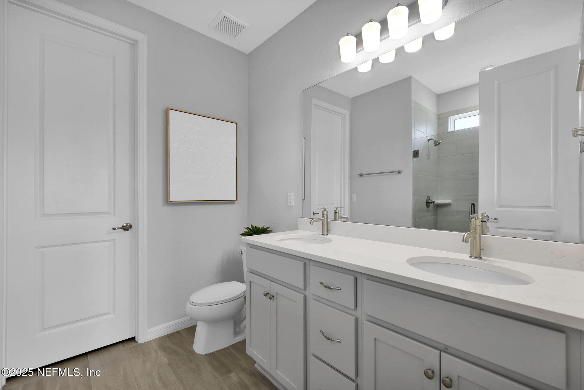 1710 Mickey Way Middleburg, FL 32068 - Photo 15 of 20 a bathroom with a toilet a sink and a mirror