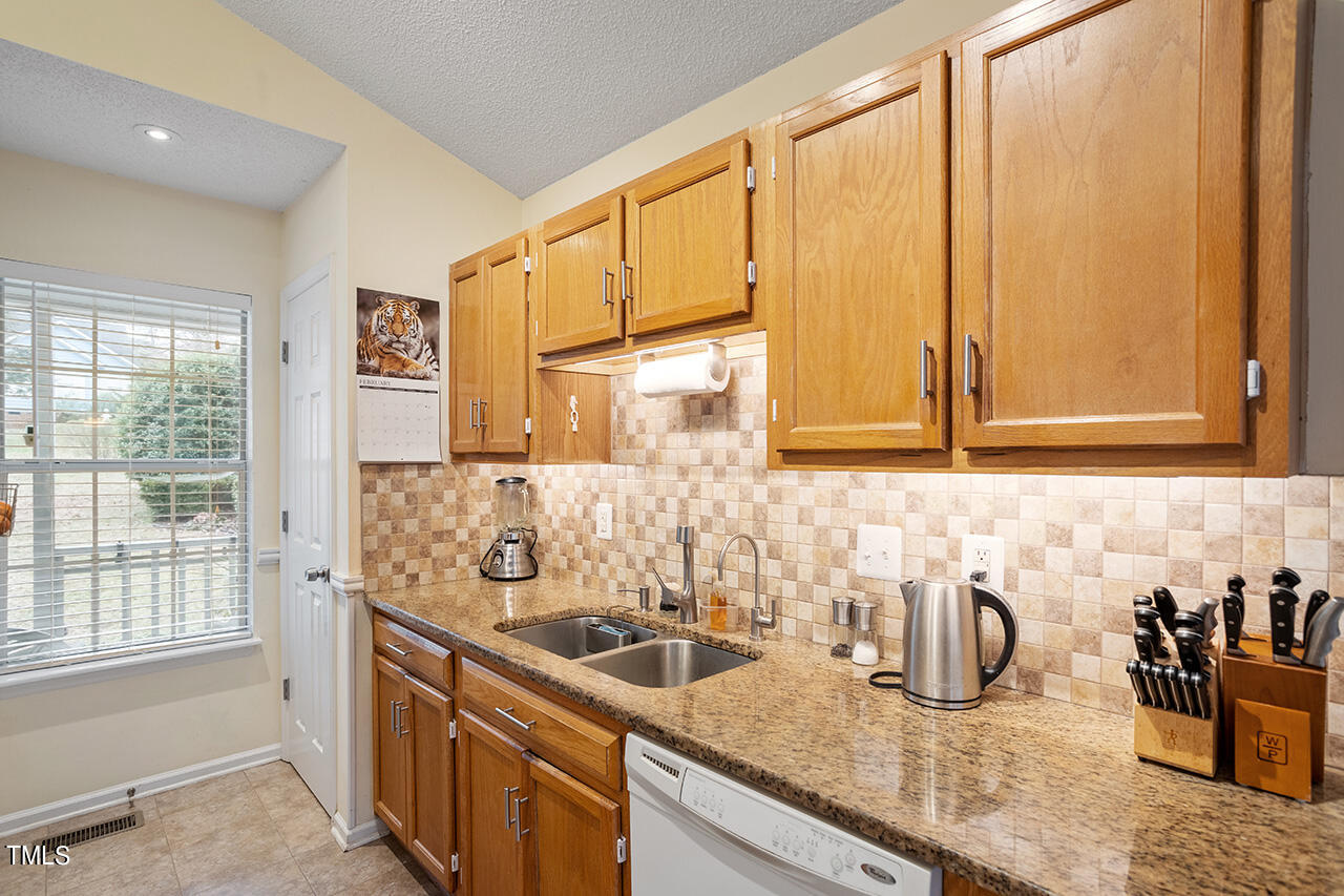 4437 Labrador Drive Raleigh, NC 27616 - Photo 14 of 25 a kitchen with stainless steel appliances granite countertop a sink and a window