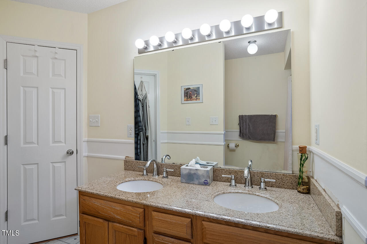4437 Labrador Drive Raleigh, NC 27616 - Photo 21 of 25 a bathroom with double vanity sinks and a mirror