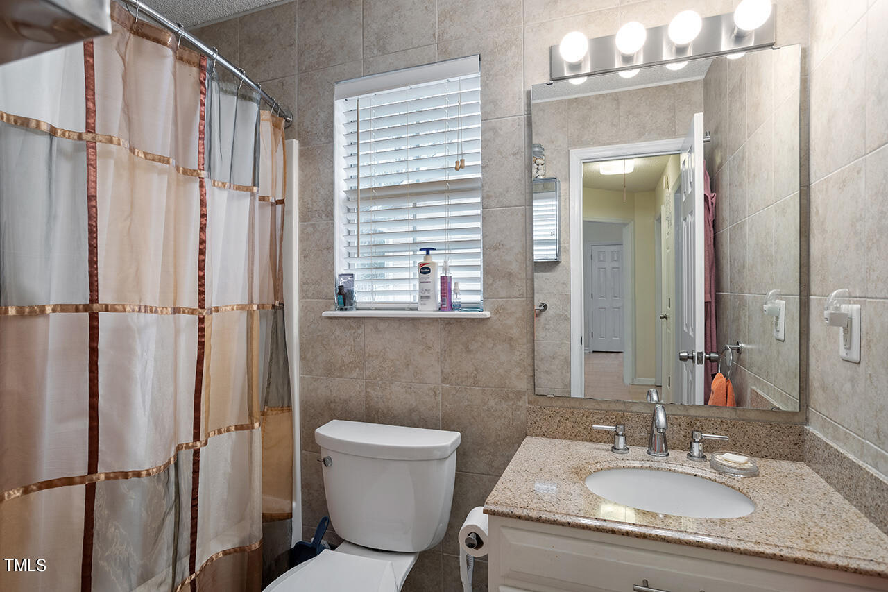 4437 Labrador Drive Raleigh, NC 27616 - Photo 25 of 25 a bathroom with a granite countertop sink toilet and shower