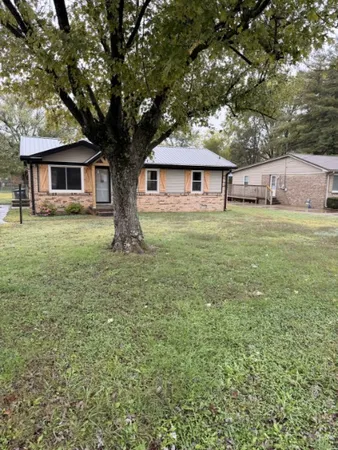 a tree in front of a white house