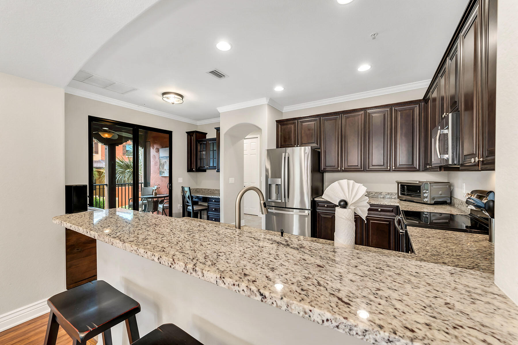 9066 Albion Lane North, Unit 5101 Naples, FL 34113 - Photo 13 of 48 a kitchen with stainless steel appliances granite countertop a refrigerator stove microwave and sink