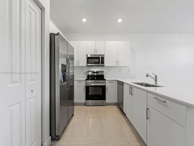 a kitchen with cabinets stainless steel appliances and a window