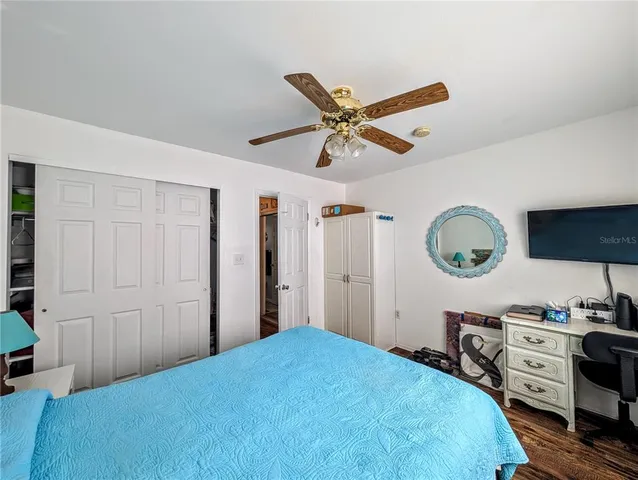 a bedroom with a bed and a flat tv screen on the dresser