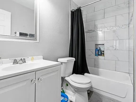 a white toilet sitting next to a bath tub