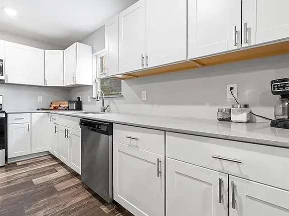 a kitchen with white cabinets and white appliances