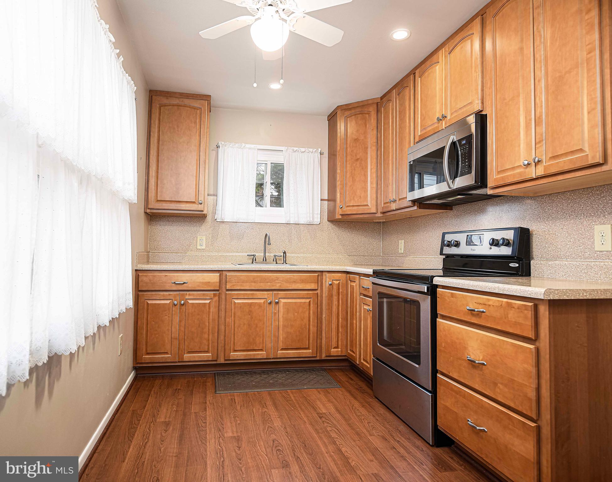 1131 Hollen Road Baltimore, MD 21239 - Photo 15 of 34 a kitchen with stainless steel appliances granite countertop white cabinets granite counter tops and a hard wood floors