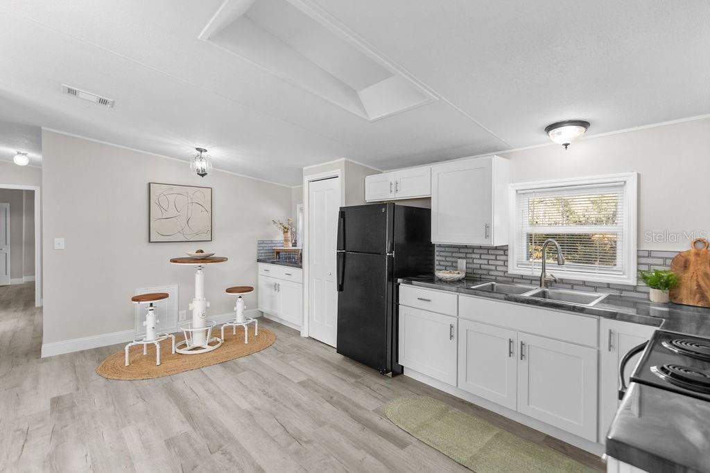 18137 Hollister Road Orlando, FL 32820 - Photo 9 of 27 a kitchen with a sink stainless steel appliances a refrigerator and a counter top space