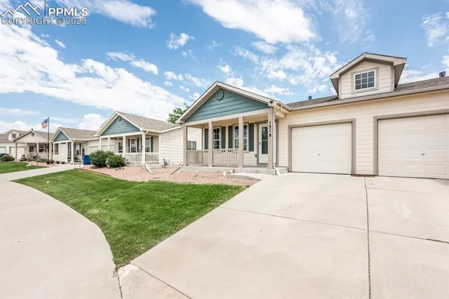 a front view of a house with a garden and yard