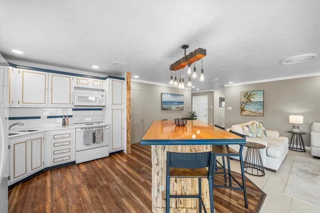 a kitchen with stainless steel appliances kitchen island granite countertop a table and chairs in it