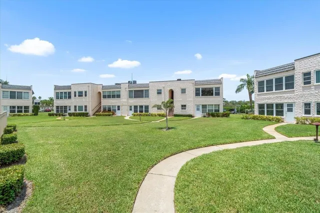 a view of an house with a big yard and potted plants