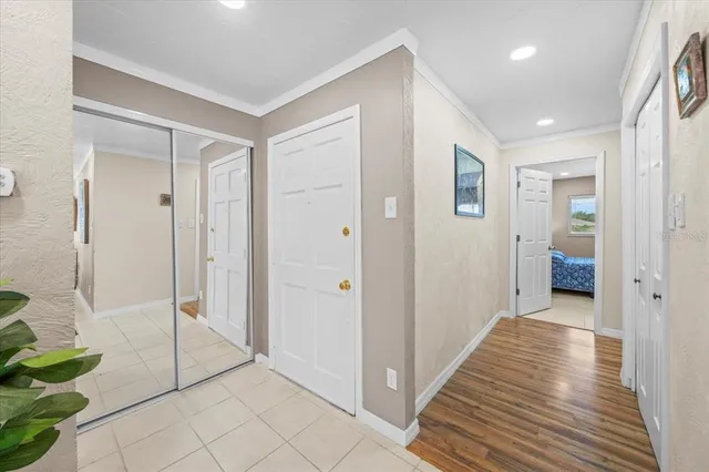 a view of a hallway with bathroom and wooden floor