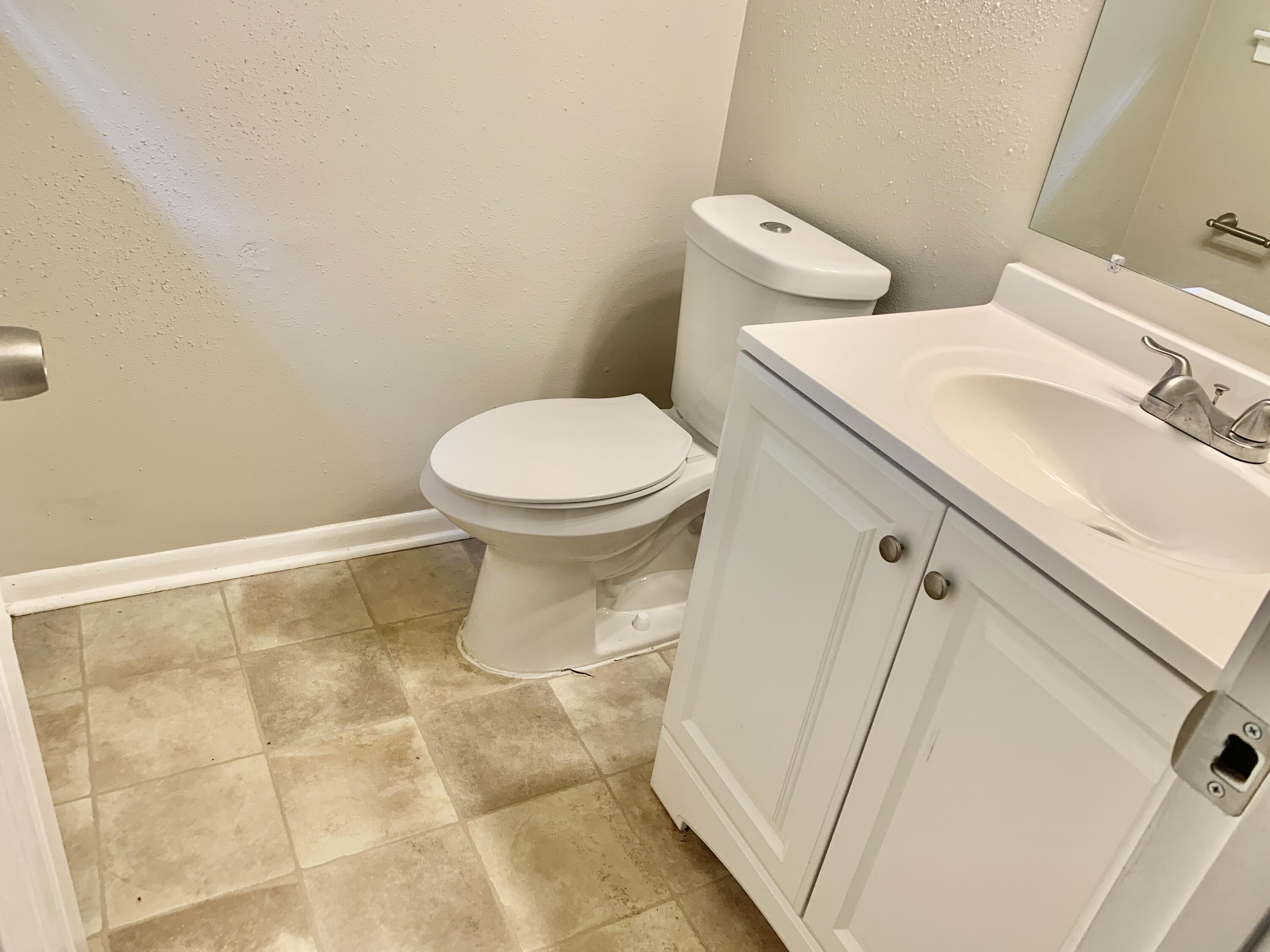 122 West 1st Avenue Crestview, FL 32536 - Photo 11 of 15 a white toilet sitting next to a bathroom sink