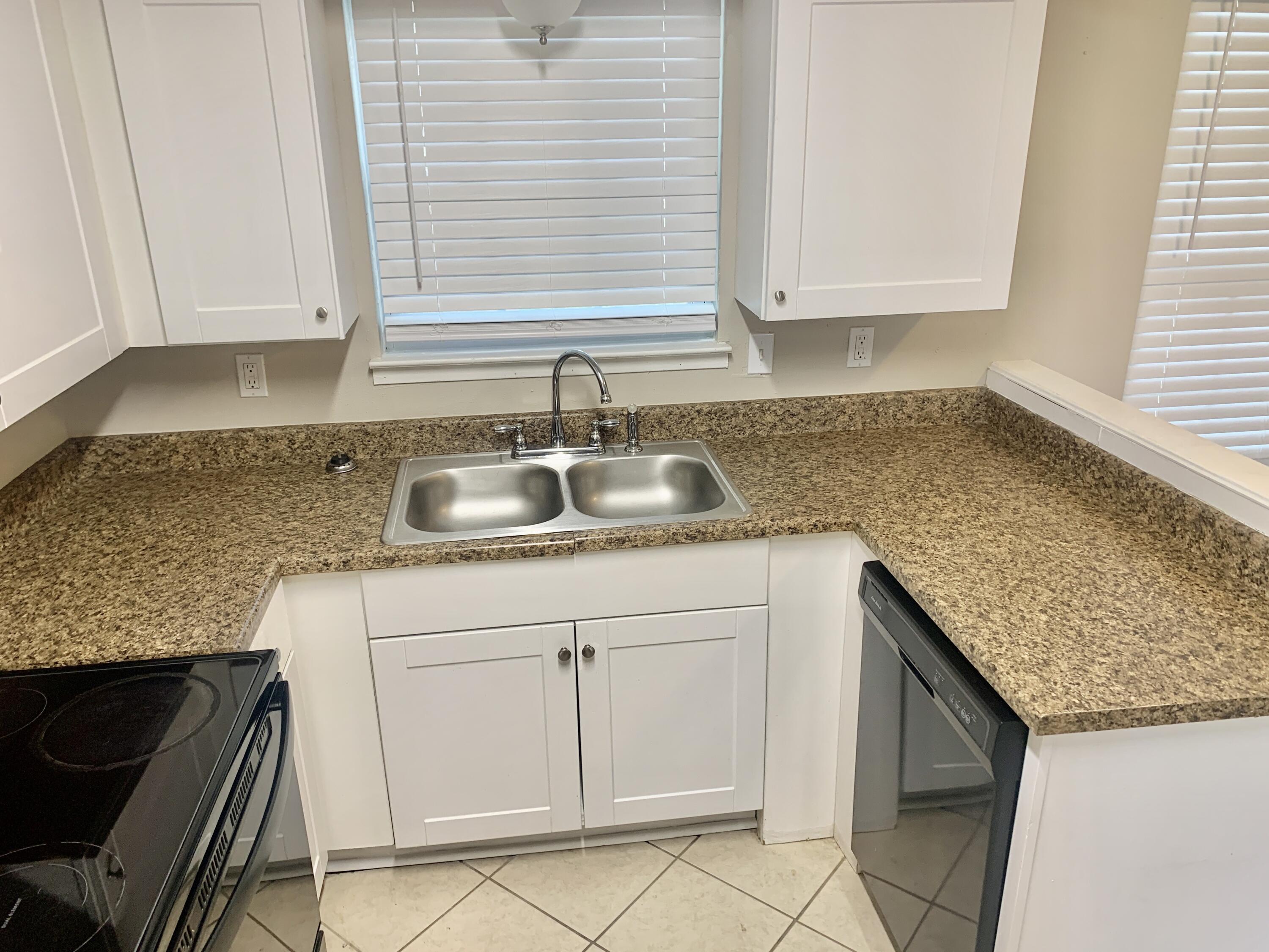 122 West 1st Avenue Crestview, FL 32536 - Photo 6 of 15 a kitchen with granite countertop cabinets sink and window