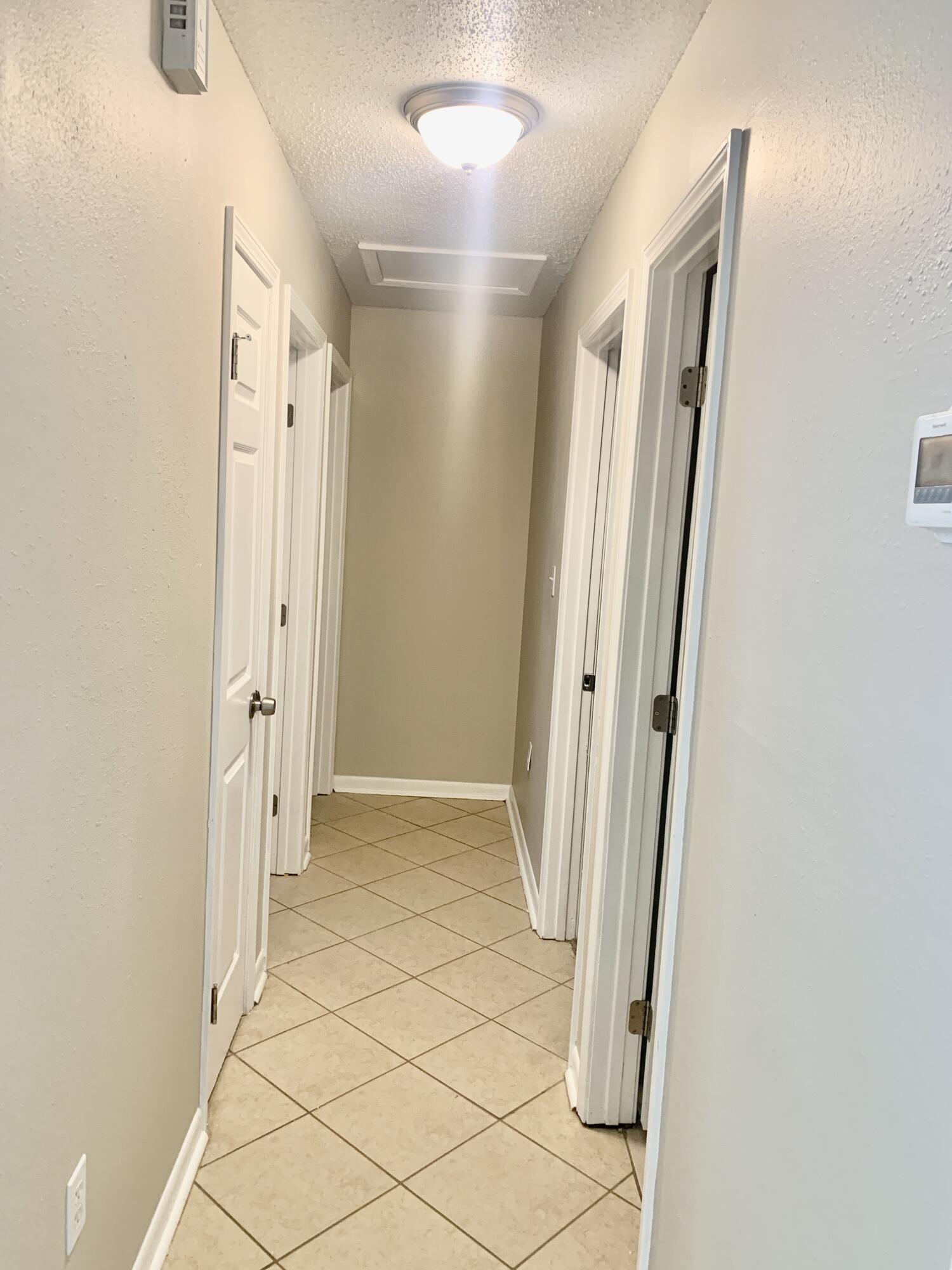 122 West 1st Avenue Crestview, FL 32536 - Photo 8 of 15 an entryway to a room with wooden floor and windows