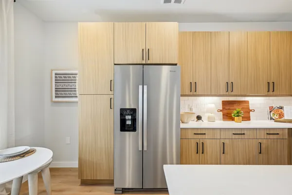 a kitchen with stainless steel appliances a refrigerator and a cabinets